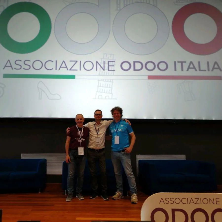 Three speakers on stage in front of the Associazione Odoo Italia banner